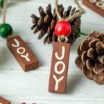 Painted wood ornaments surrounded by pinecones.