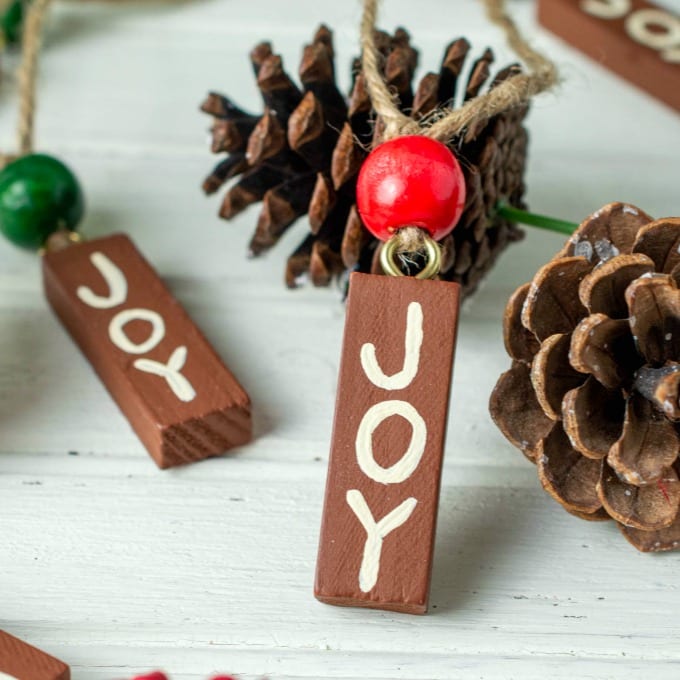 Close up of Painted Wood Ornaments with the word JOY.