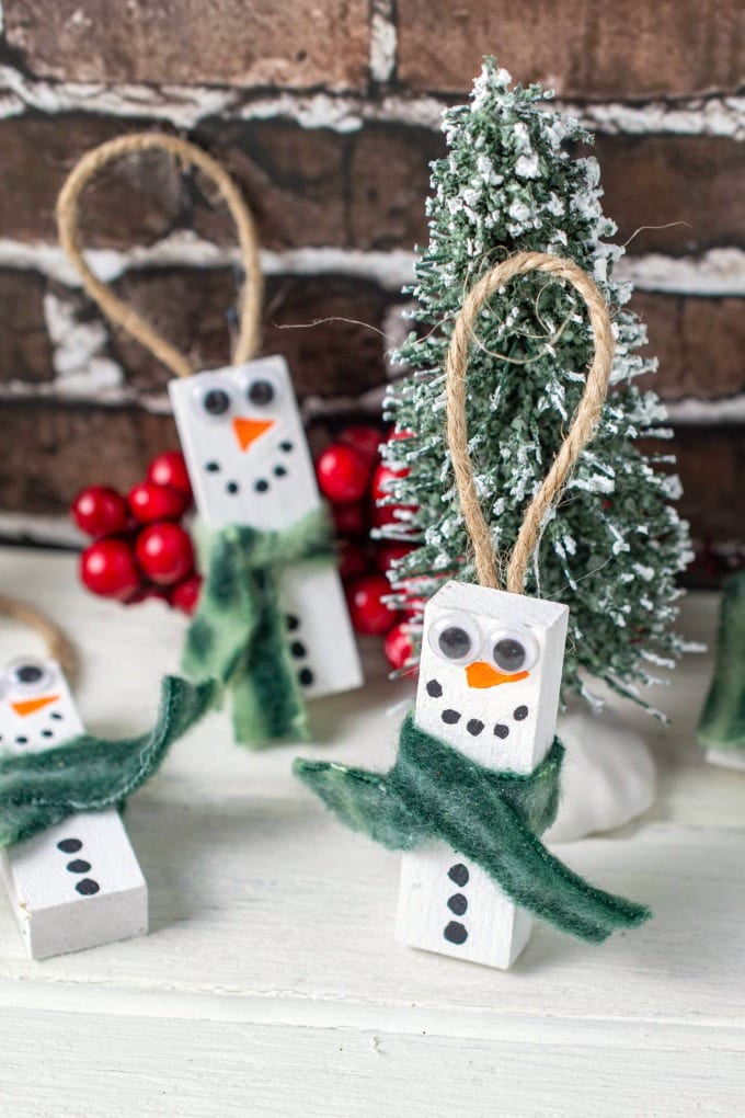 close up of Wooden Snowman Ornaments made of blocks pictured with bottle brush trees.