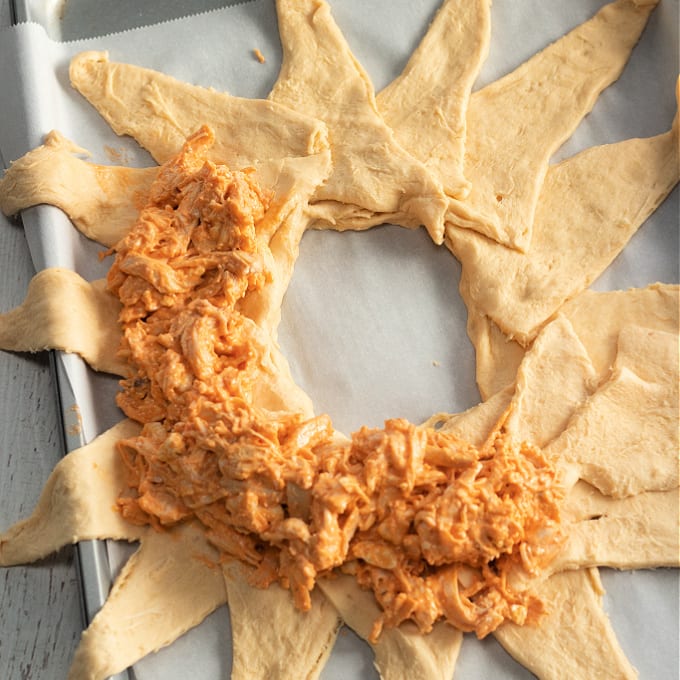 How to Make a Buffalo Chicken Crescent Ring - process photo showing how to lay out the crescent rolls to make the crescent roll buffalo chicken ring and then add the buffalo chicken dip filling.