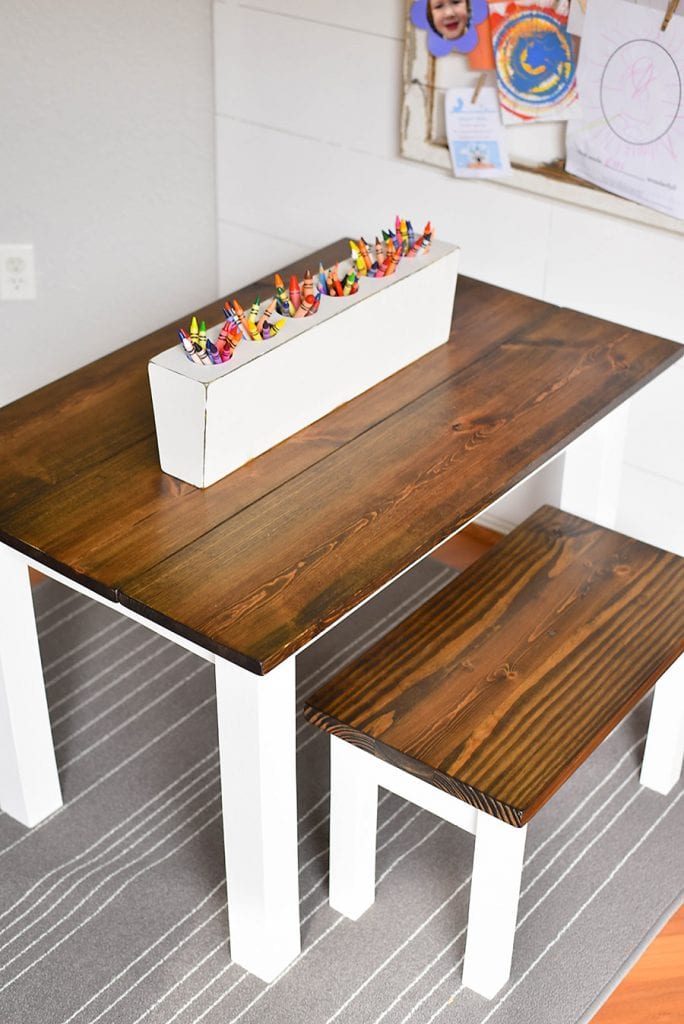 Painted white DIY farmhouse table with stained wood top for children.