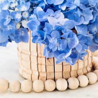 Close up image of a clothespin basket with a wood bead garland.
