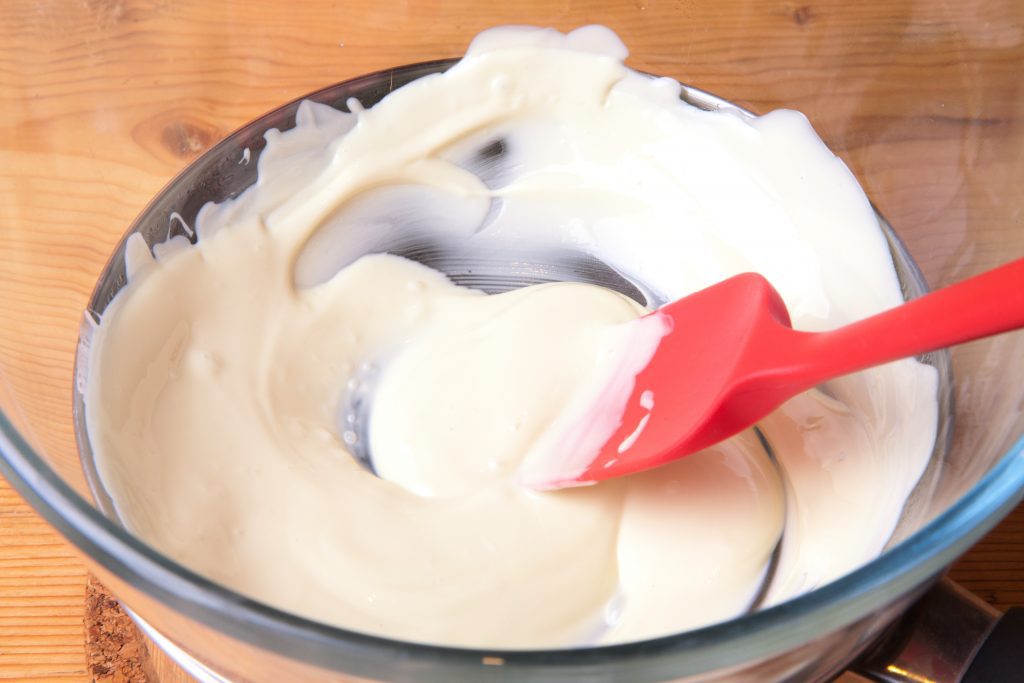 Melted white chocolate in the glass bowl.