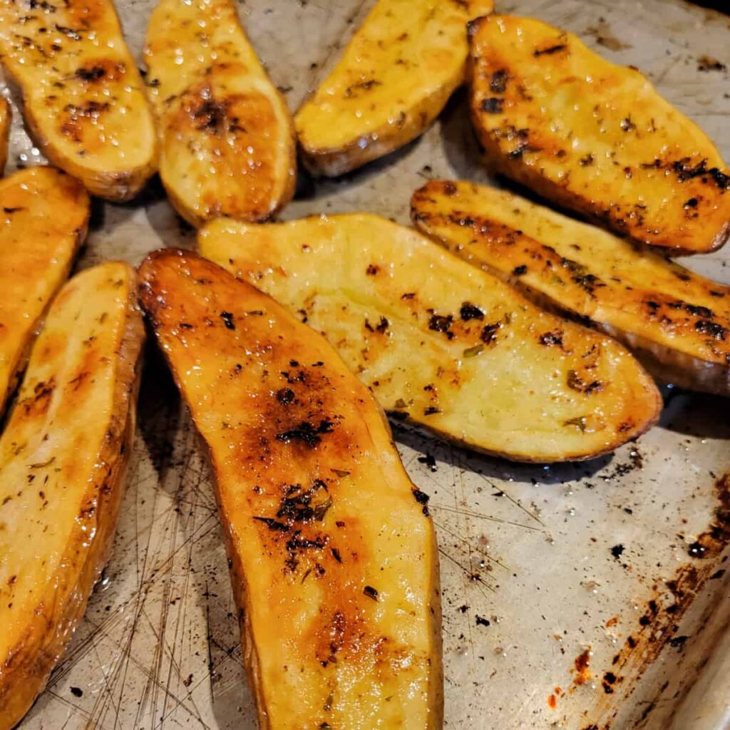 close up of golden brown Crispy Fingerling Potatoes on a rimmed baking sheet