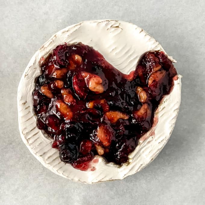 Creamy brie cheese with a cutout of a turkey filled with cranberry walnut sauce.