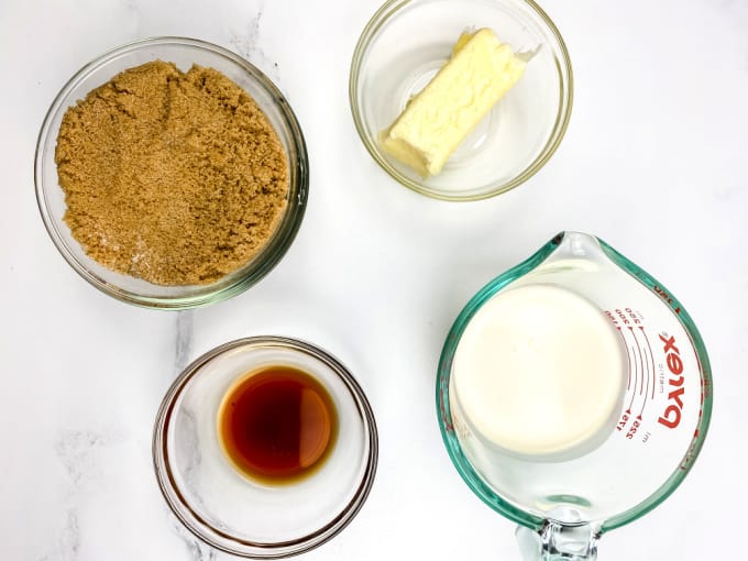 Top down image of ingredients to make homemade caramel sauce - brown sugar, butter, vanilla and whipping cream.