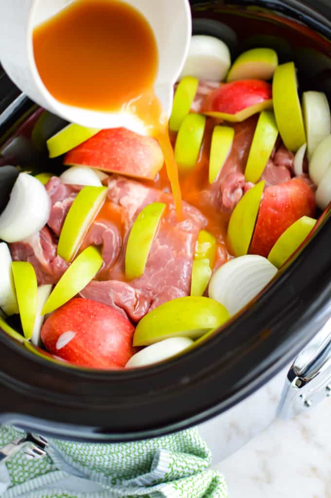 Slow cooker full of pork loin, apples, onions.