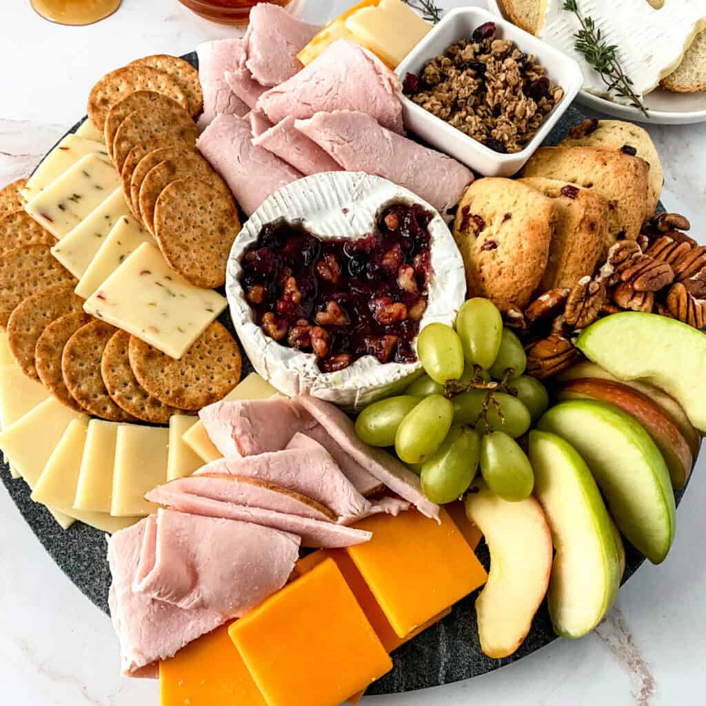 Square image of a Thankgiving charcuterie board on a marble counter top. 