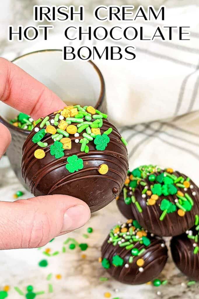 Hand holding one Irish cream hot chocolate bomb decorated for st patrick's day