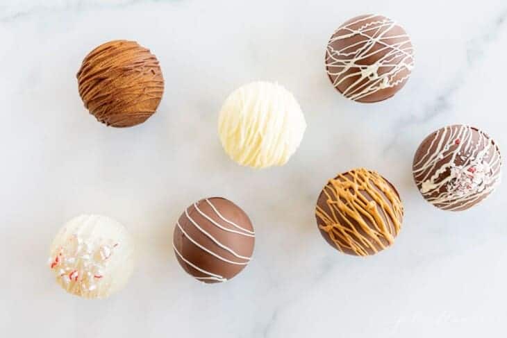 Top down image of a variety of hot chocolate bombs in white and milk chocolate.