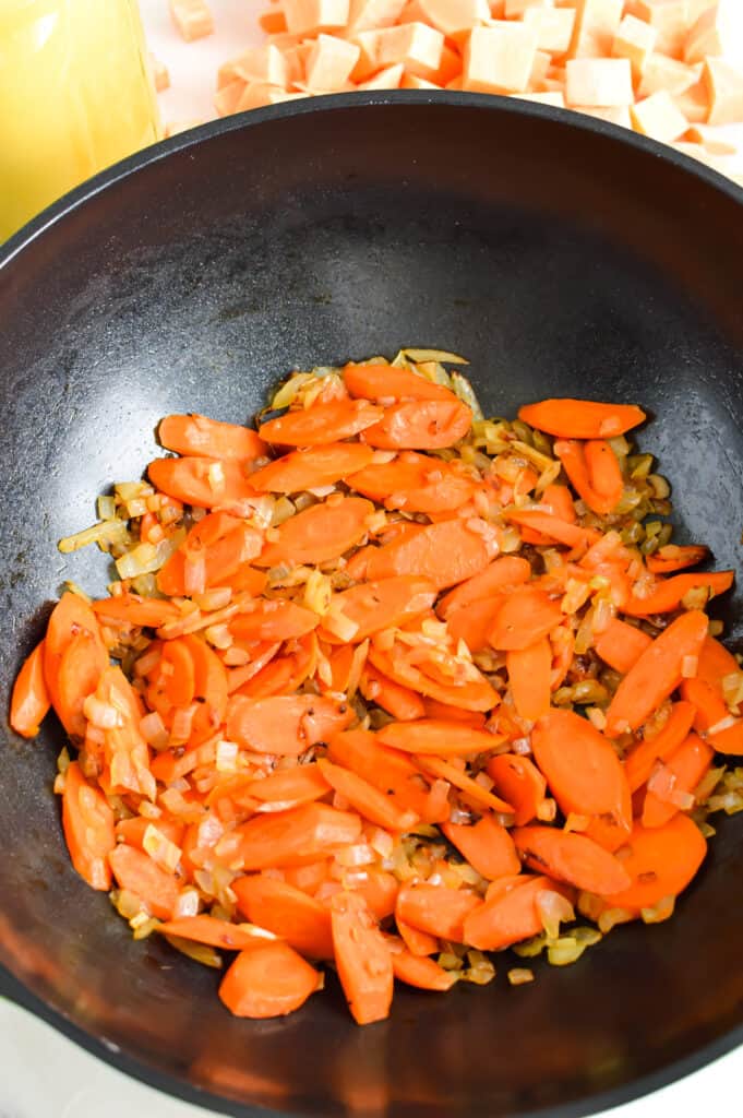 Carrot and onion mixture in a skillet.