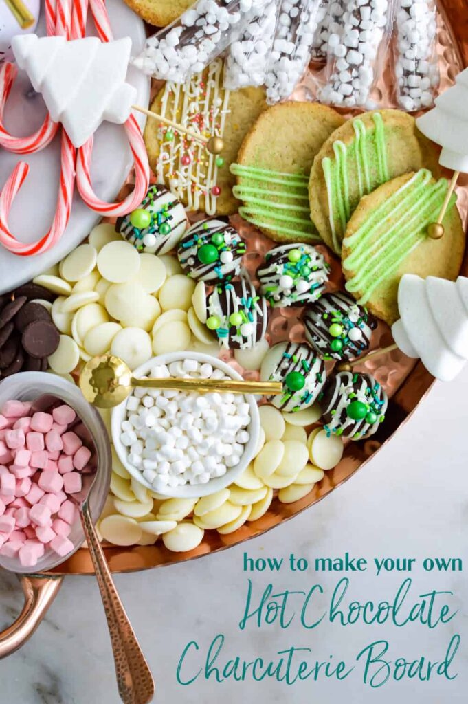 Close up, top-down view of a cocoa charcuterie board filled with cookies, chocolate truffles and hot cocoa fixings.