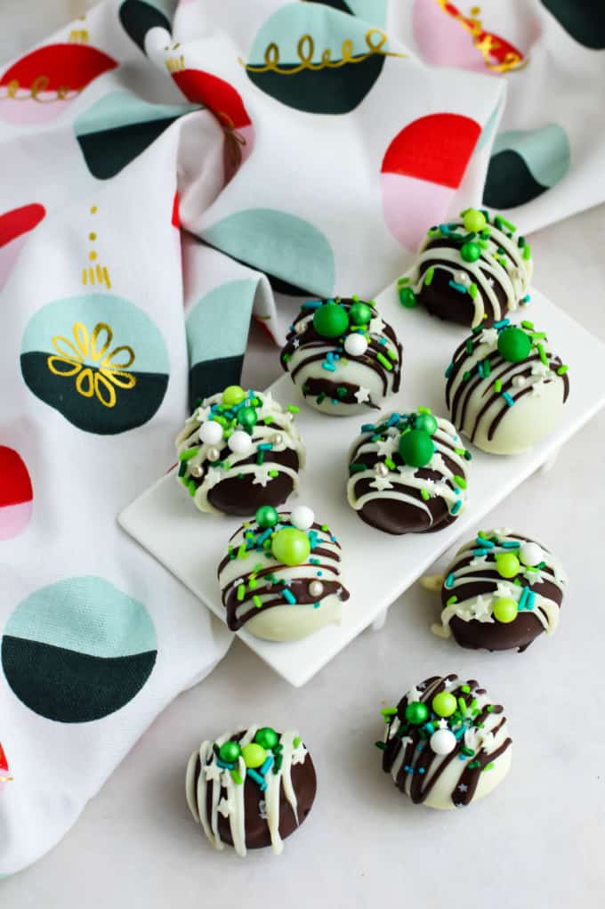 Image contains Oreo Truffle balls on a white dish and countertop next to festive Christmas fabric.