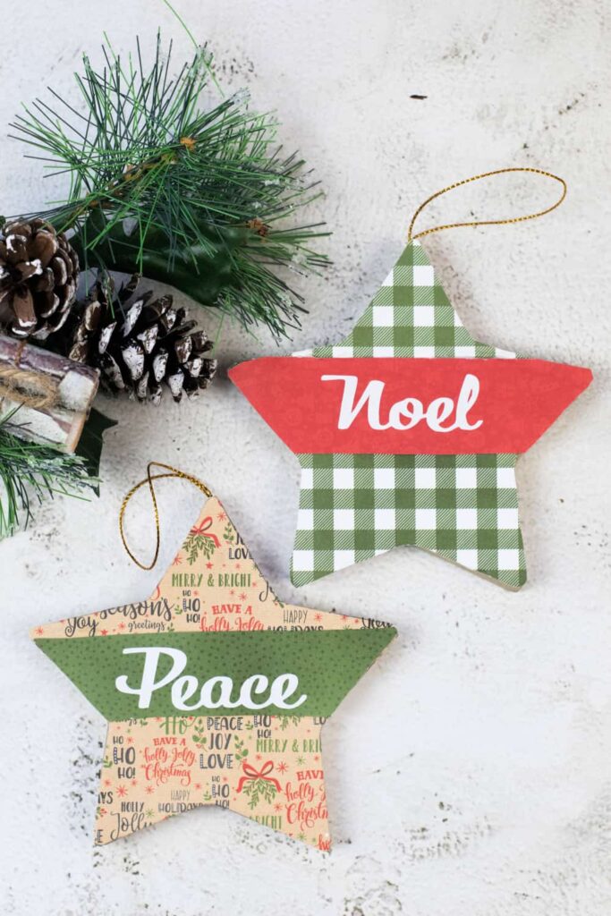 Two paper mache ornaments on a white surface with greenery.