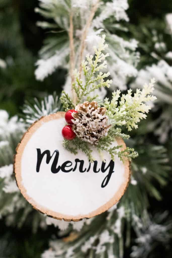 Close up image of a wood circle ornament with the word Merry.