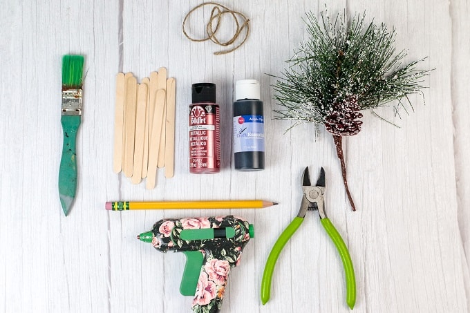 Materials and equipment needed to make popsicle stick sled ornaments. 