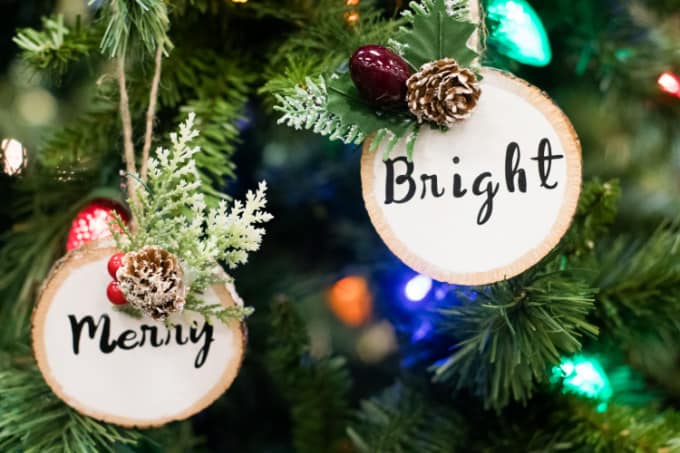 Close up image of two wood circle Christmas ornaments that say Merry and Bright.