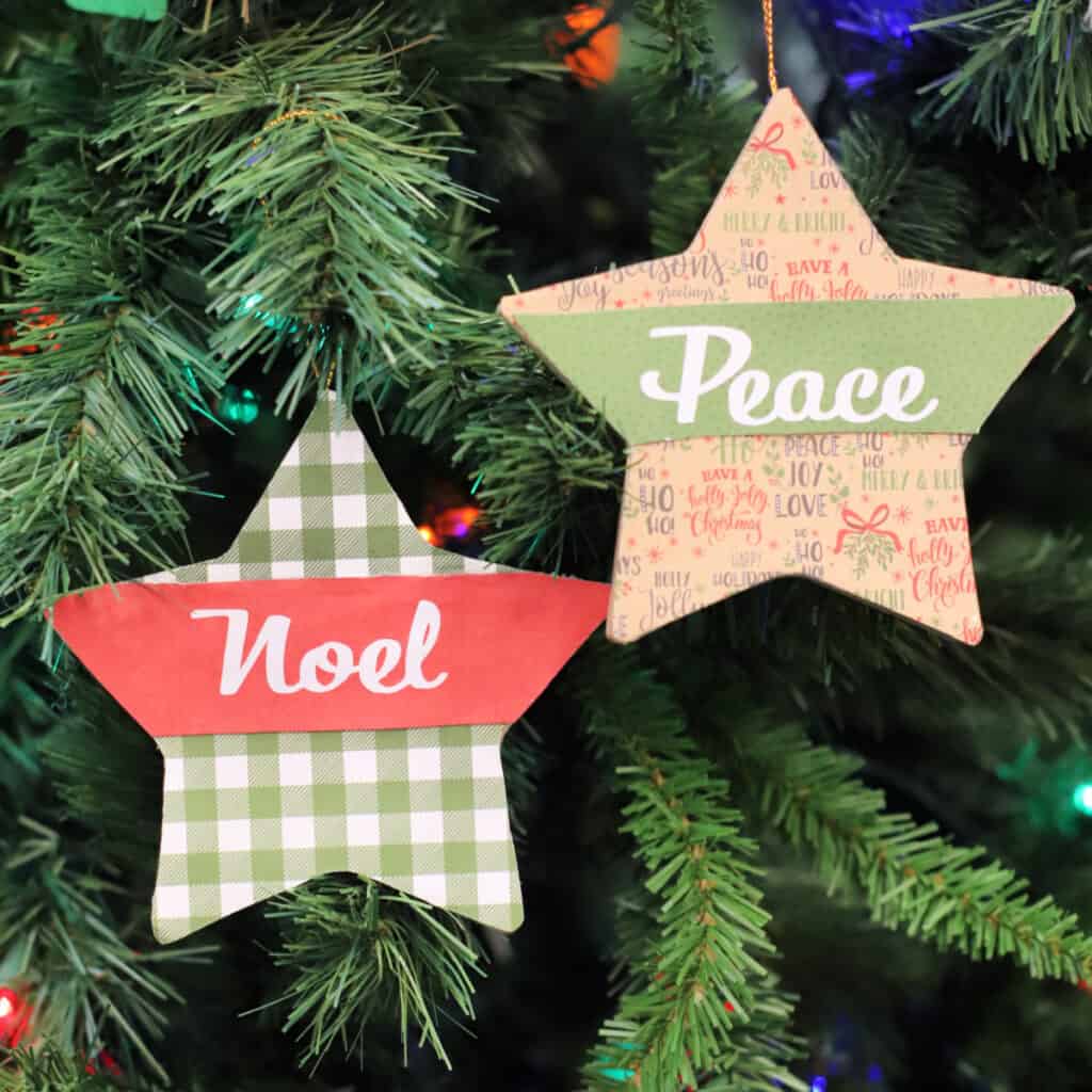 Two paper mache ornaments hanging from a Christmas tree. 
