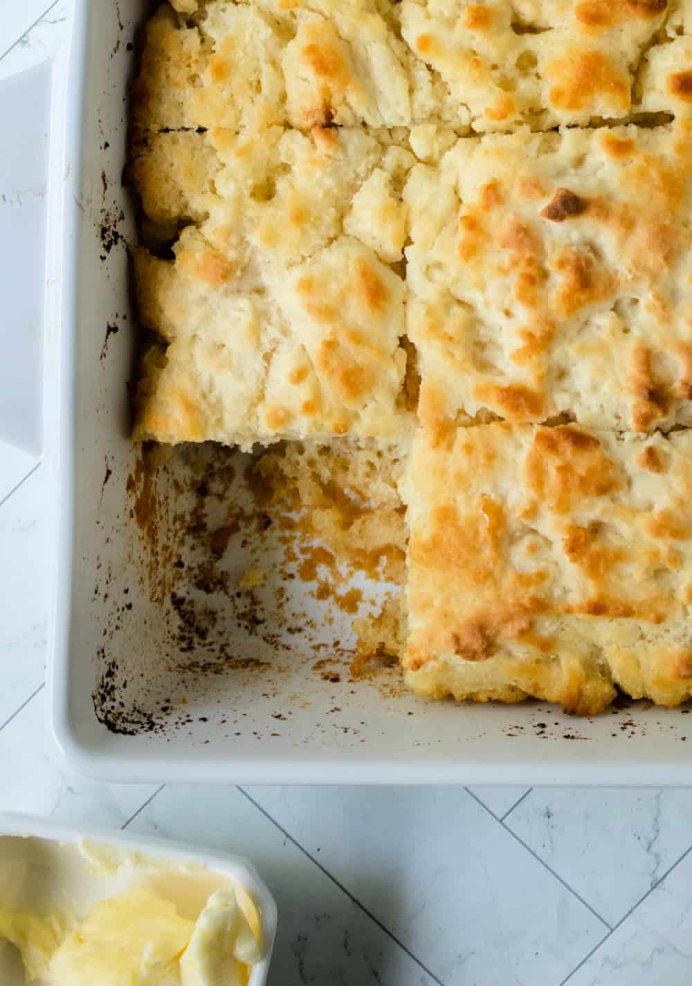 Close up image of a baking dish with slices of butter swim biscuits.
