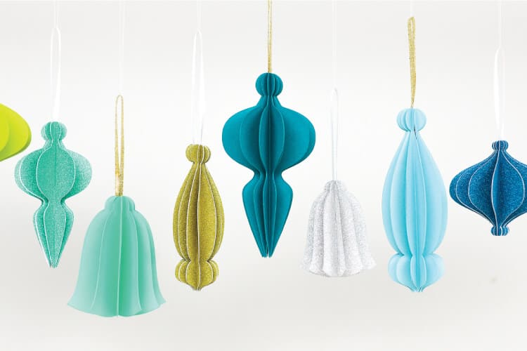 Retro look cut paper ornaments hanging from ribbon.