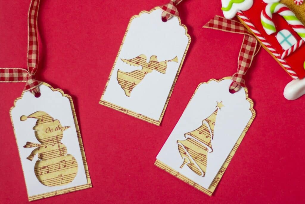 Three holiday ornaments cut in the shape of gift tags.