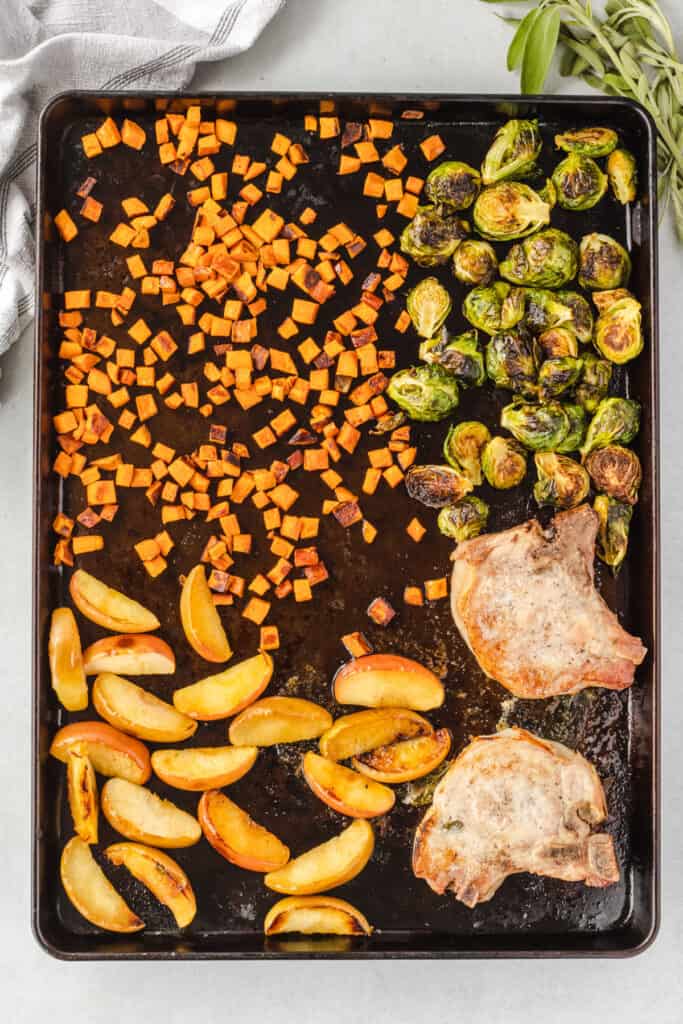 Top down view of sheet pan pork chops with roasted vegetables.