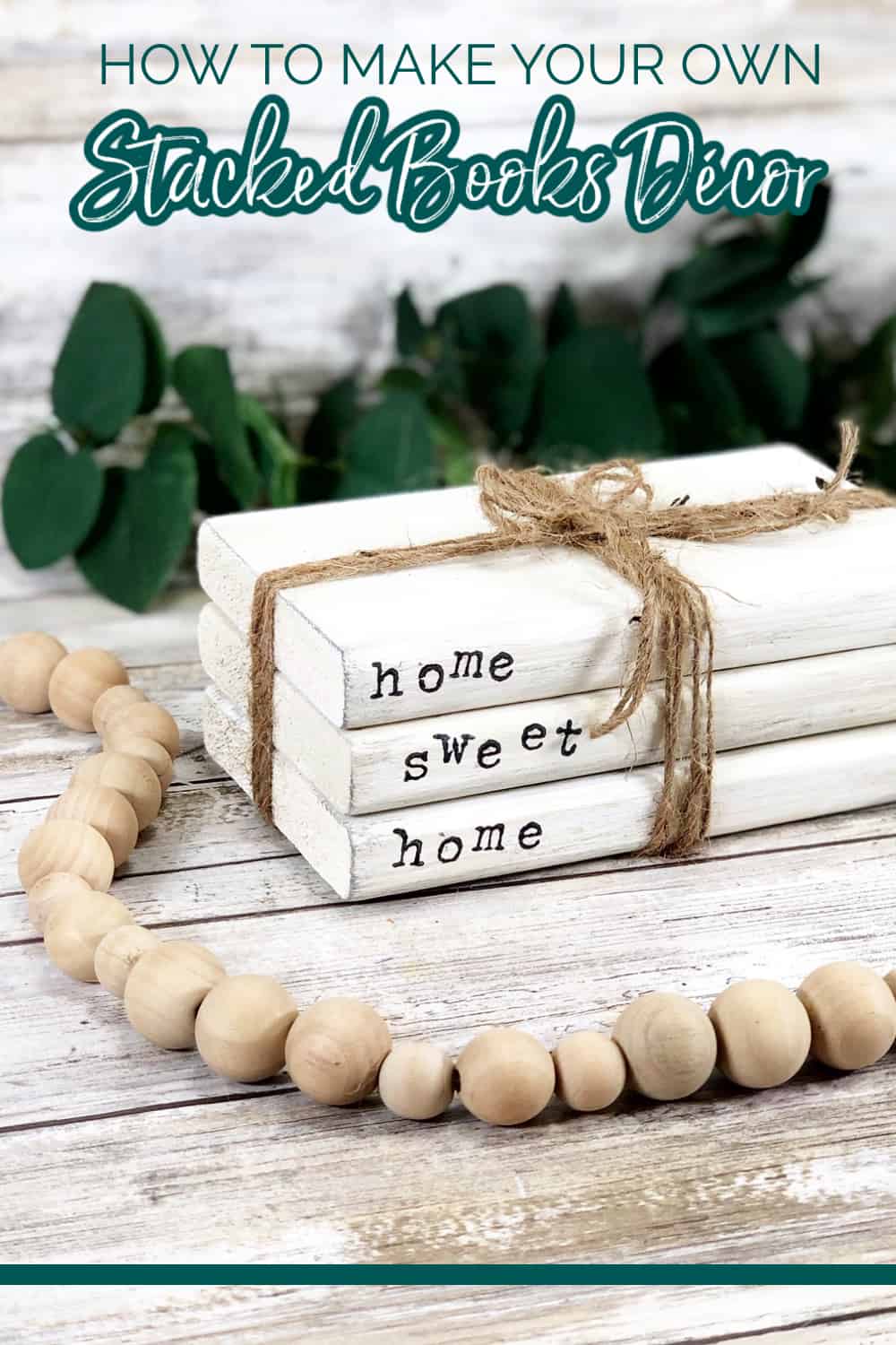 Close up image of a DIY book stack tied together with twine and surrounded by a wooden bead garland.