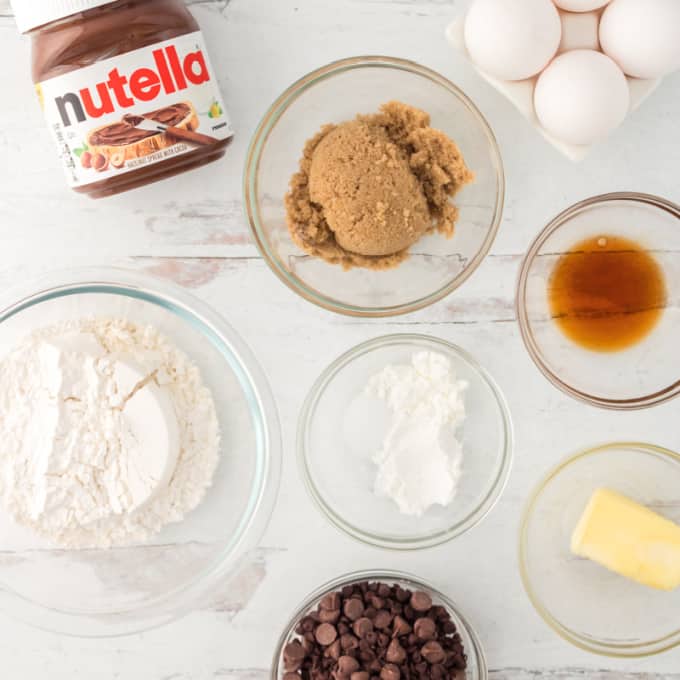 Top down view of ingredients to make chocolate chip cookies stuffed with nutella.