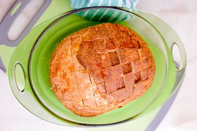 Top down image of a loaf of bread sliced most of the way through into squares.