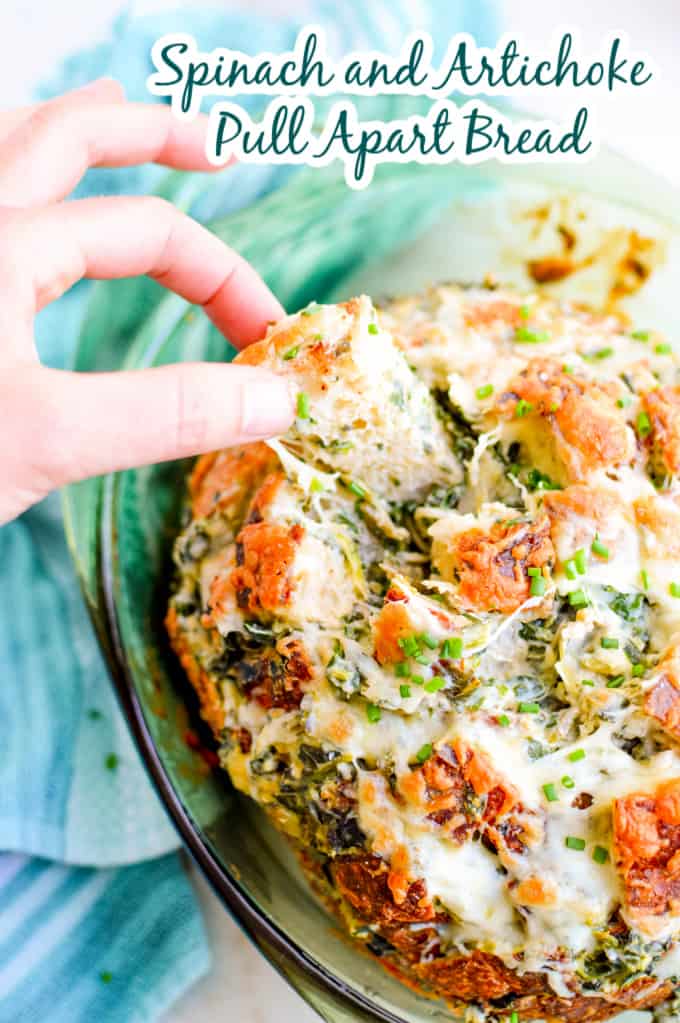 Woman pulling apart spinach and artichoke bread.