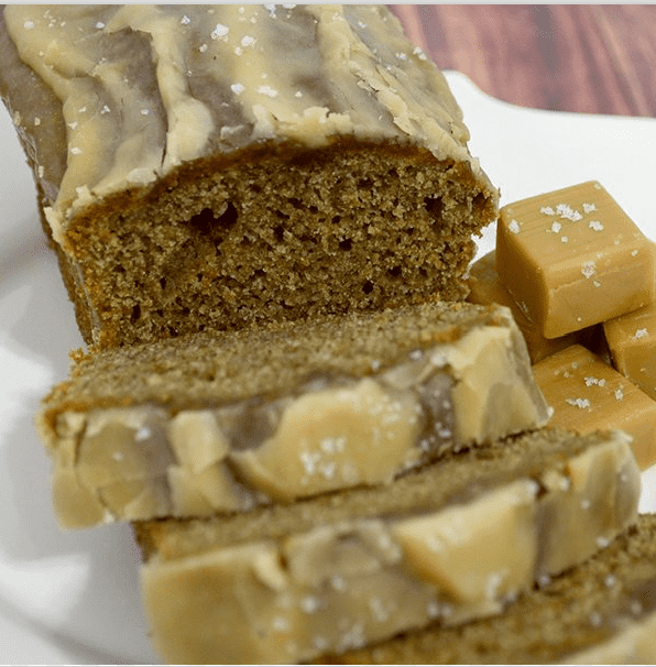 Close up image of salted caramel banana bread on a white plate with caramel candies.