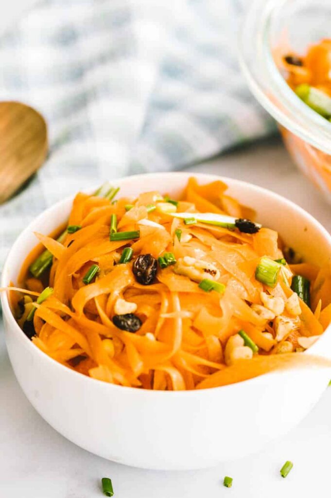 Close up image of carrot salad with raisins.