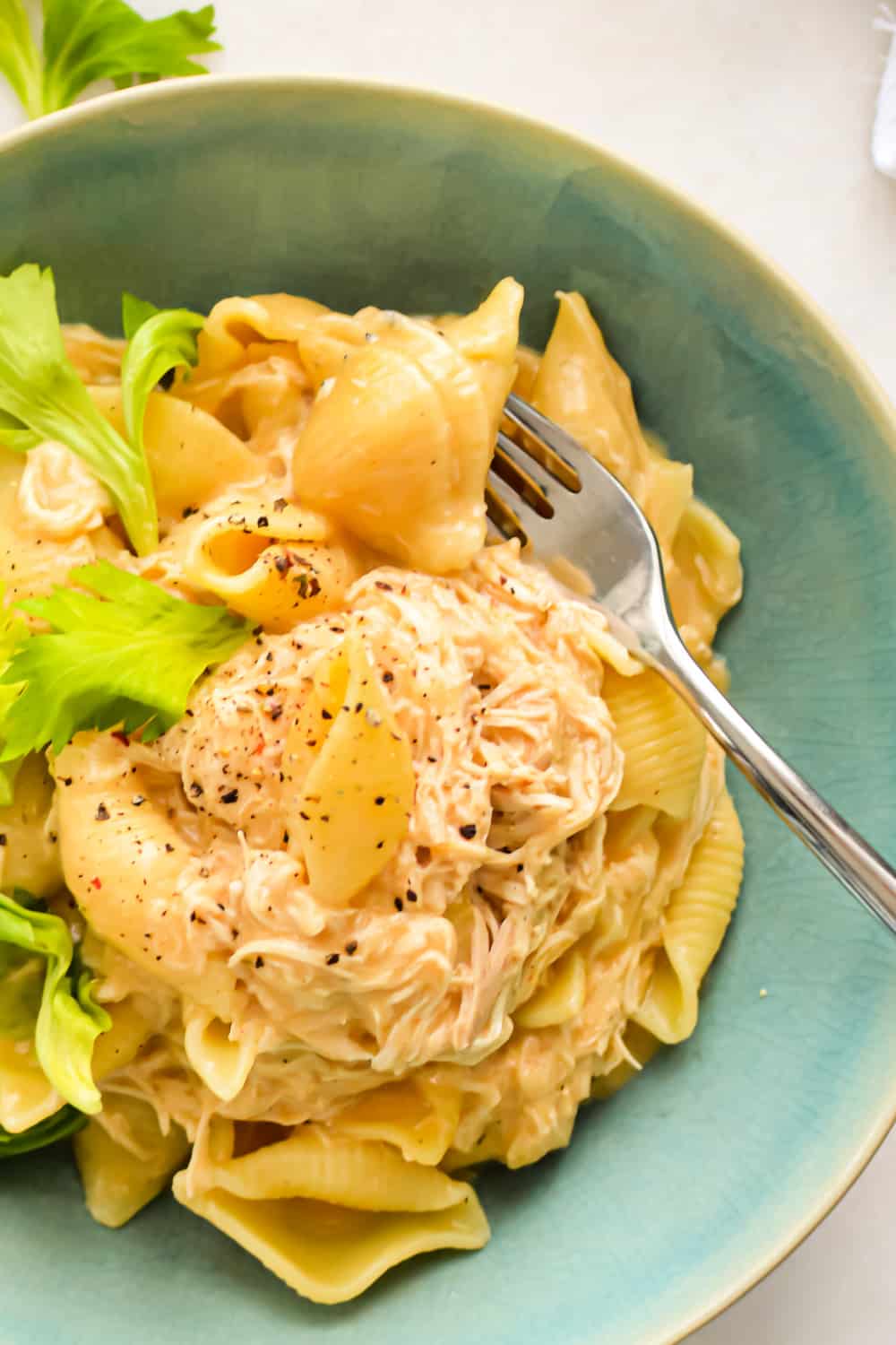 Close up of Slow Cooker Buffalo Chicken Mac and Cheese in a bowl with a fork.