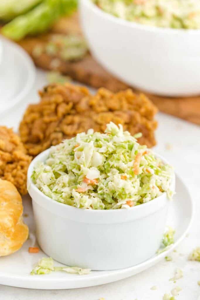 KFC coleslaw in a small ramekin on a plate with fried chicken.