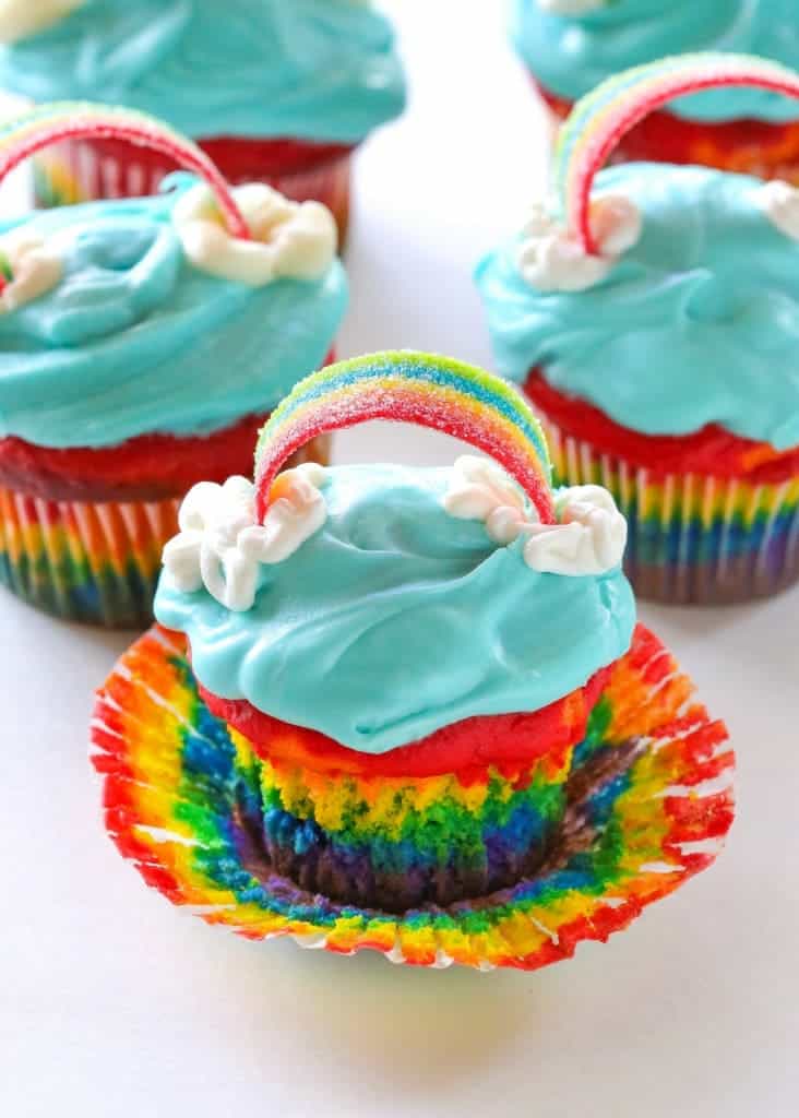 Tie dye cupcakes with rainbows on top.