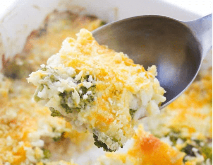 Close up of a Chicken and Rice Casserole with Broccoli on a serving spoon.