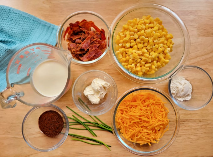 Bowls of ingredients to make Cowboy Corn Casserole including milk, bacon, corn, cheese, cream cheese, flour, and cowboy seasoning mix.