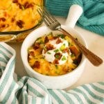 Close up of Chicken Hashbrown Casserole in a bowl with a fork.
