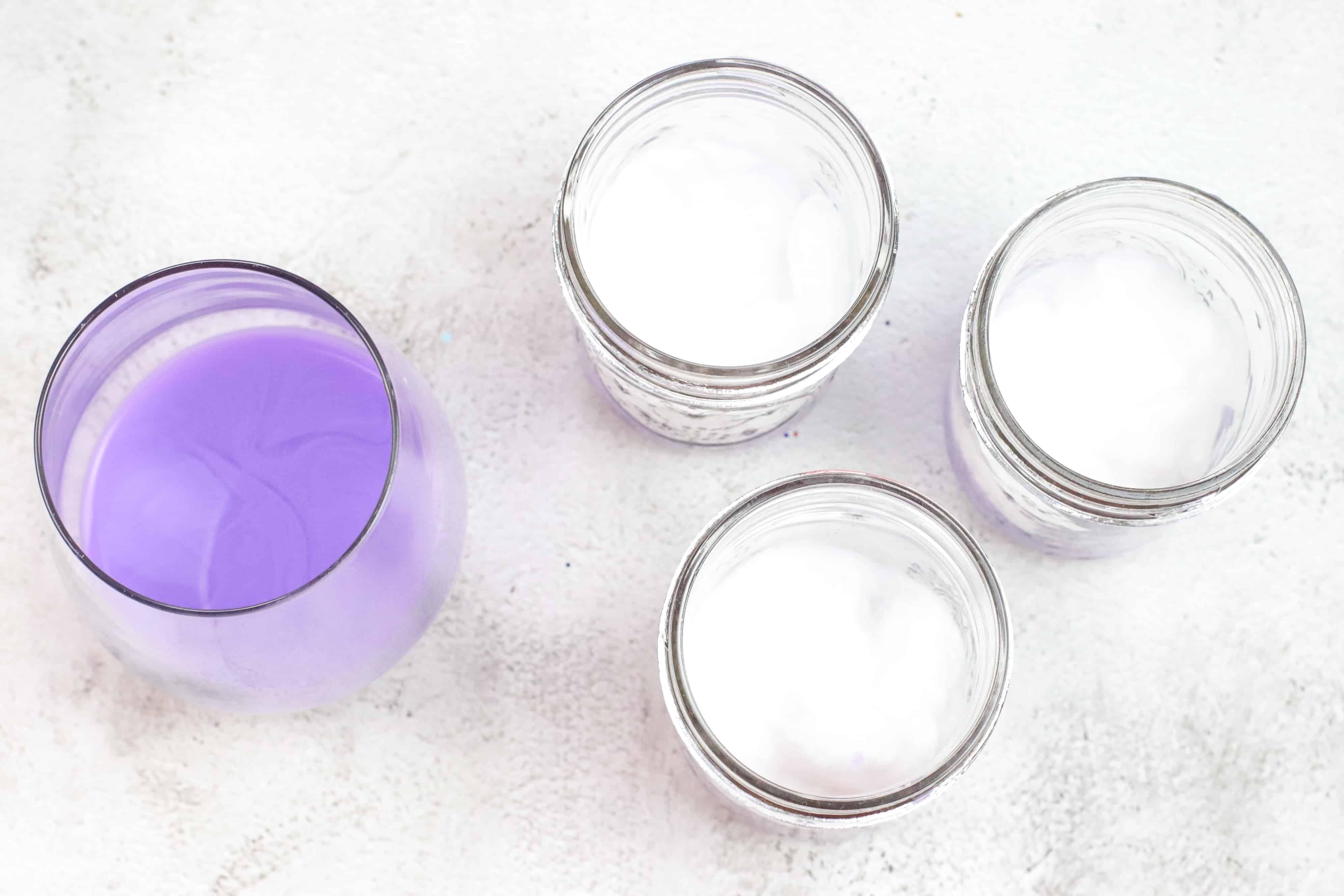 glass of paint and three jars with cotton