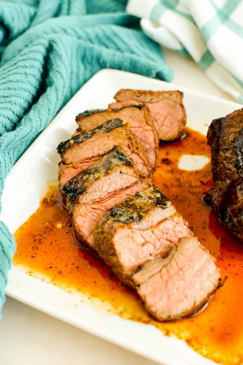 Slices of grilled top sirloin on a white plate.