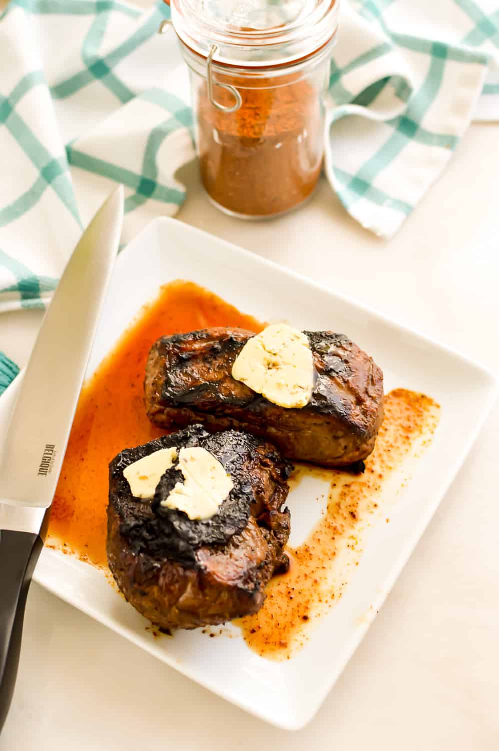 Grilled Top Sirloin Steak on a white plate next to a knife.
