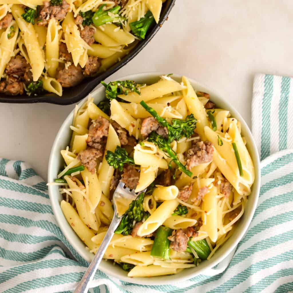 Square image of Pasta with Sausage and Broccolini in a bowl with a fork.
