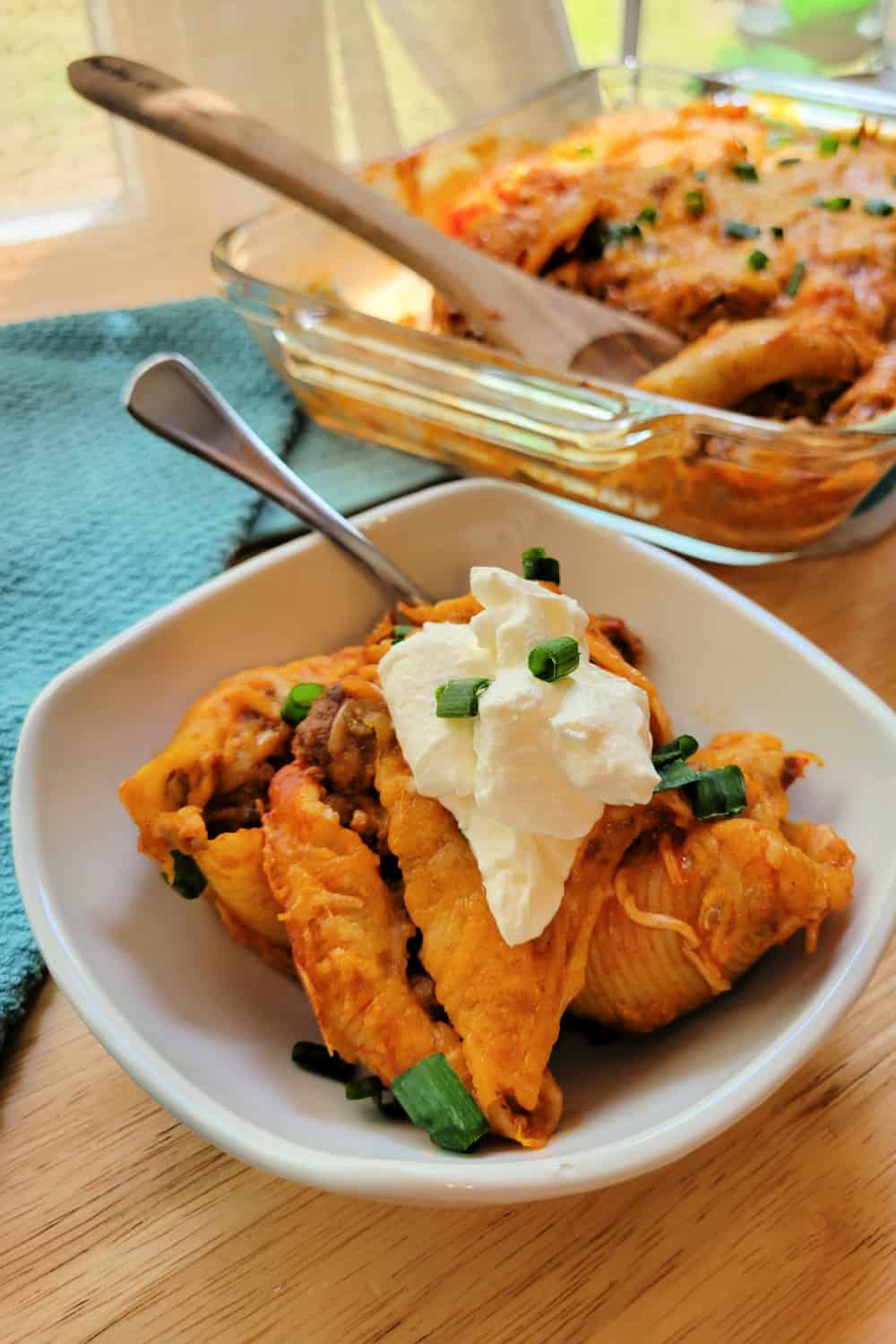 Taco Stuffed Shells topped with sour cream in a white bowl.