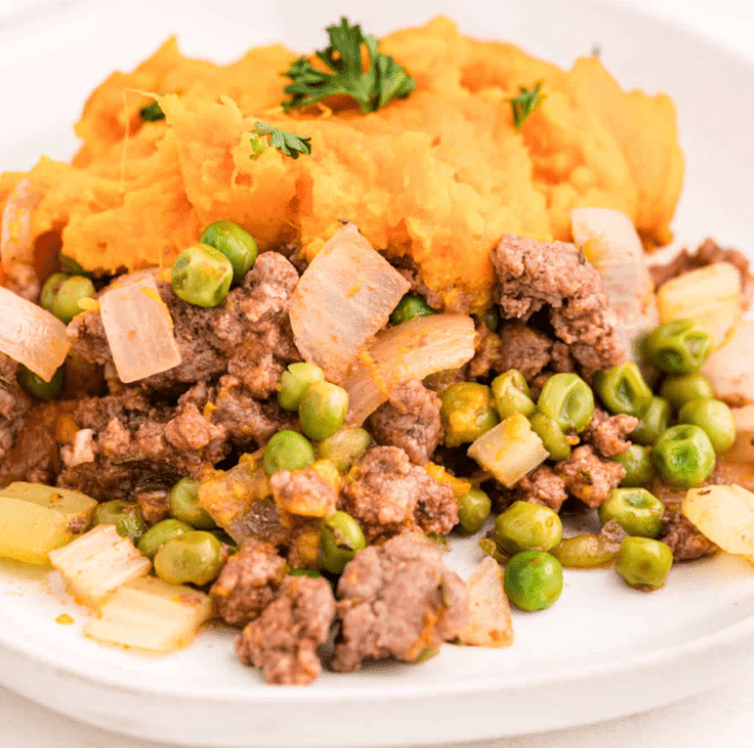 Close up Shepherd's Pie with Sweet Potato with peas and onions on a plate.