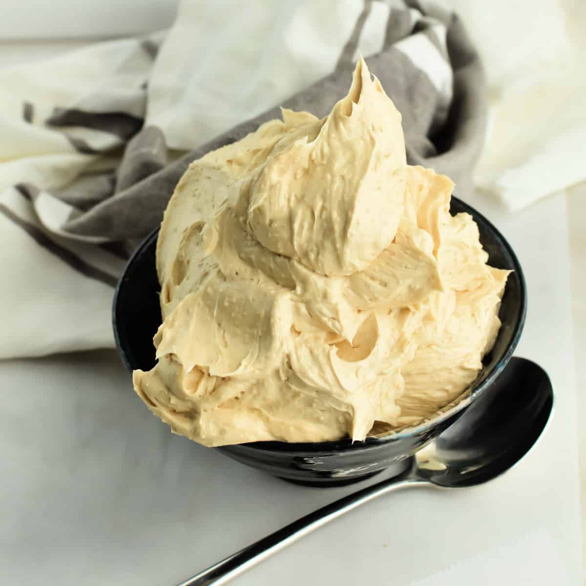 Whipped Brown Sugar Butter in a bowl next to a spoon.