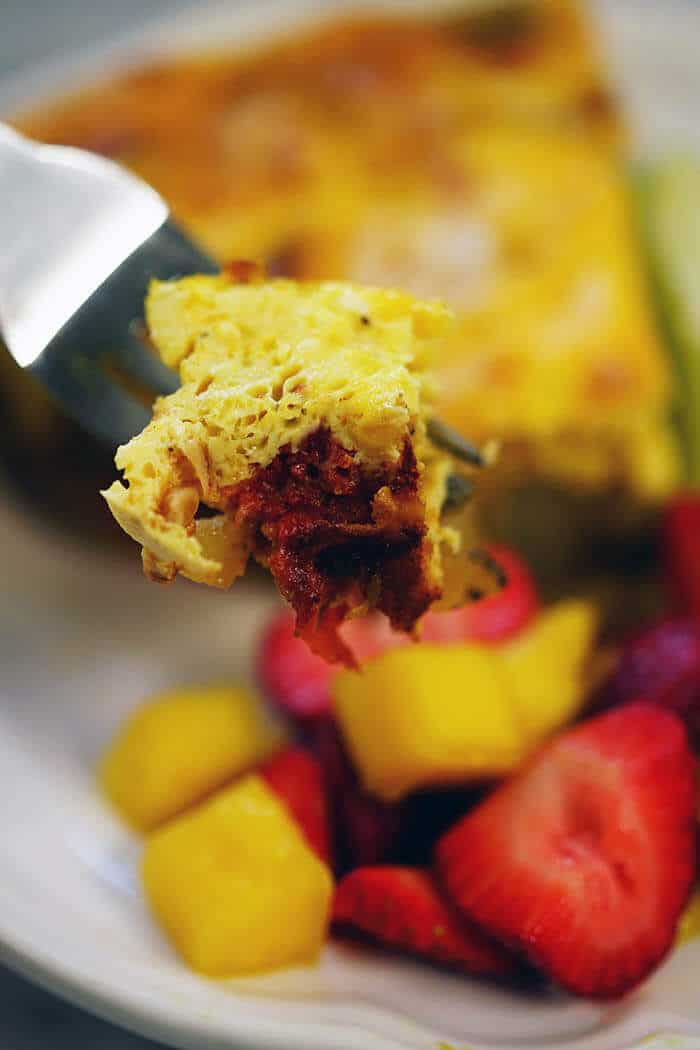 A white place with a serving of this easy frittata recipe. There's a close up of a fork full of frittata, ready to devour!