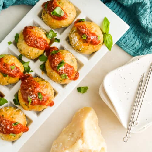 Square image of Keto Chicken Meatballs topped with tomato sauce.