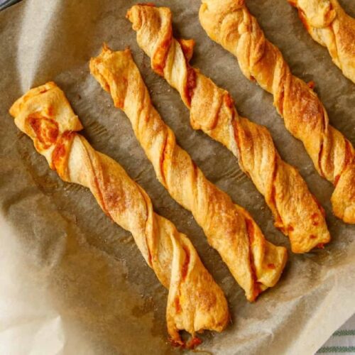 Baked Pumpkin Spice Puff Pastry Twists on a baking sheet with parchment paper.