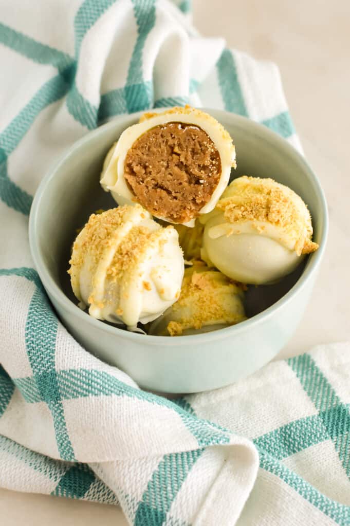 Close up of white chocolate Pumpkin Cheesecake Balls with crushed graham crackers.
