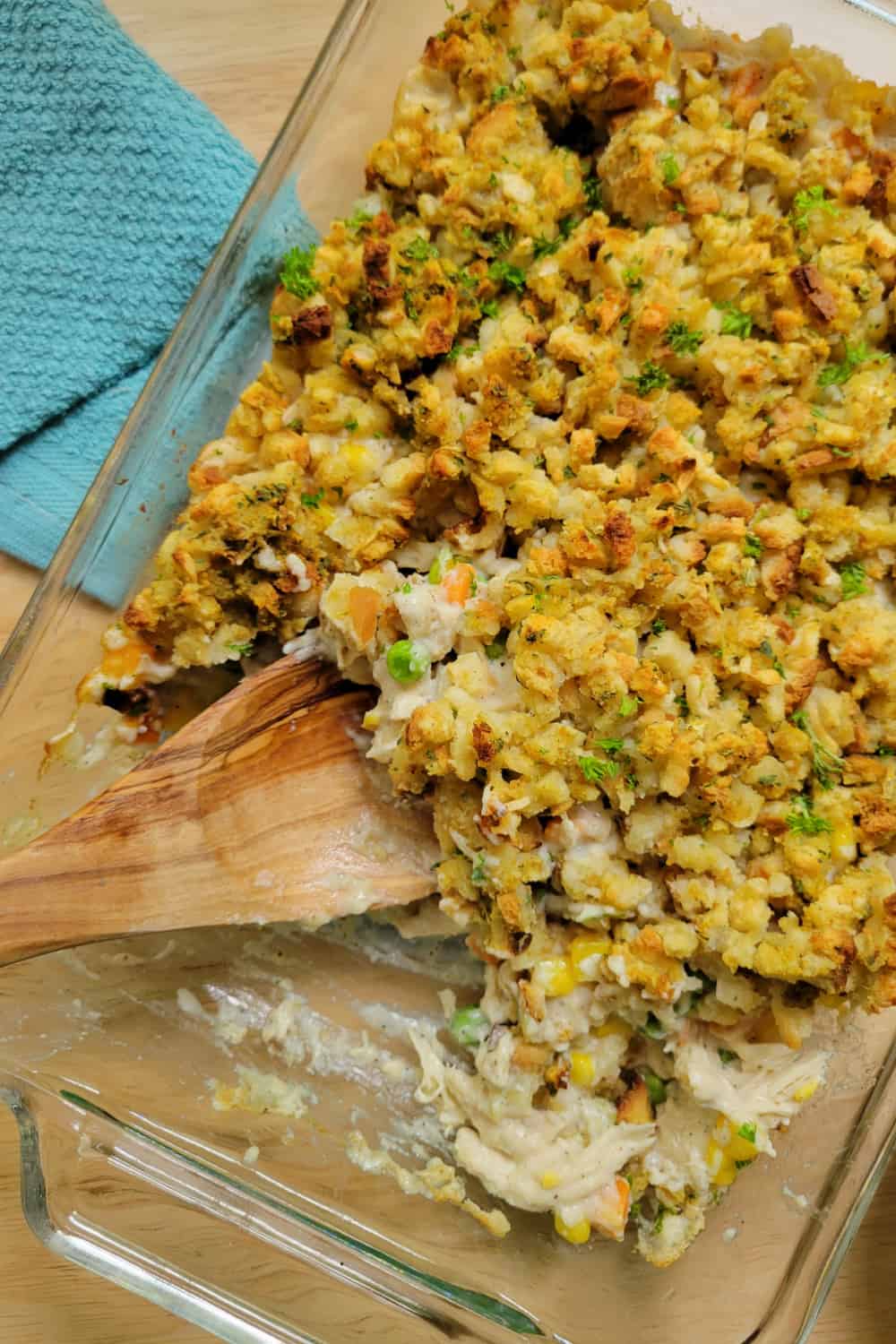 Top down view of easy Chicken Stuffing Bake in a casserole dish with a wooden spoon.
